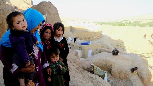 A group of women and children standing on top of a cliff.