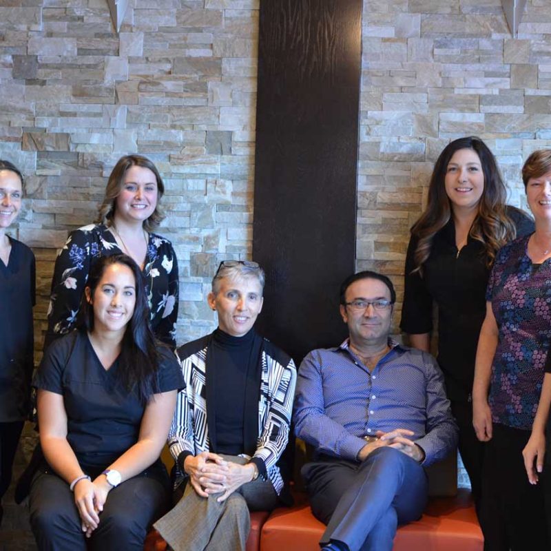 A group of people posing for a photo in a dental office.