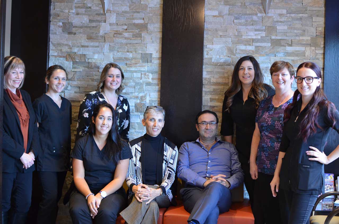 A group of people posing for a photo in a dental office.