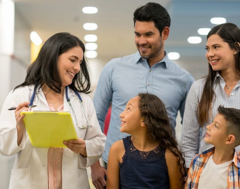 A family with a doctor looking at a clipboard.