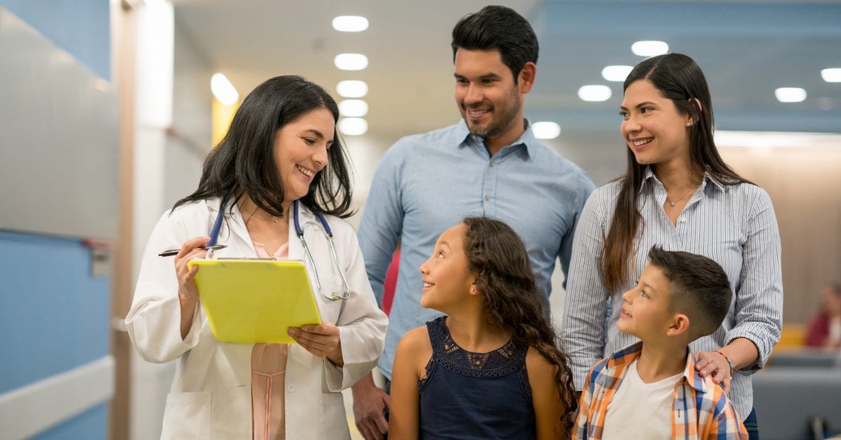 A family with a doctor looking at a clipboard.