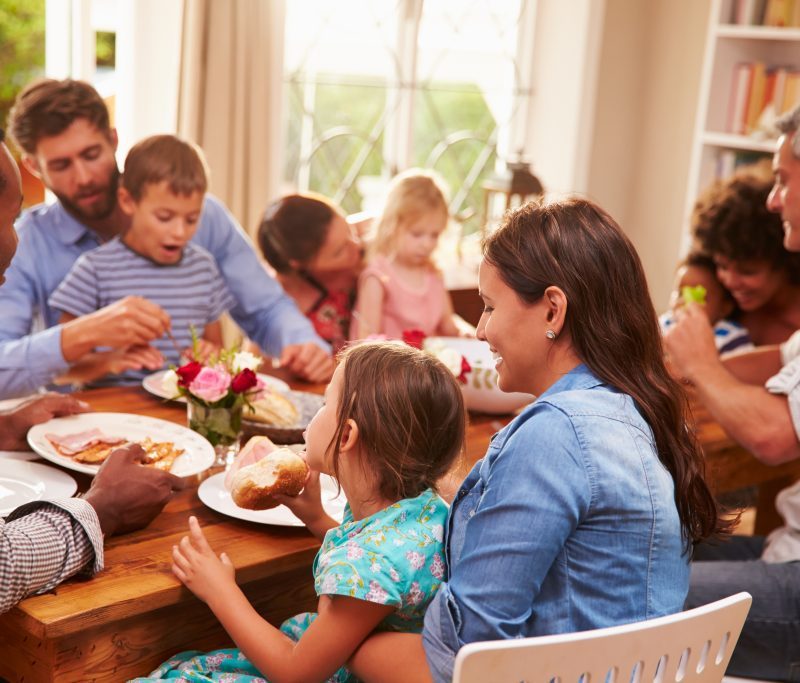 A family sits around a table and eats together.