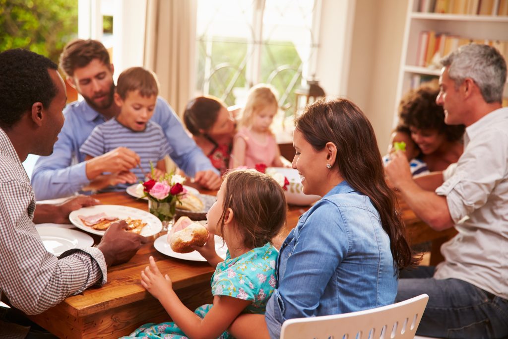 A family sits around a table and eats together.